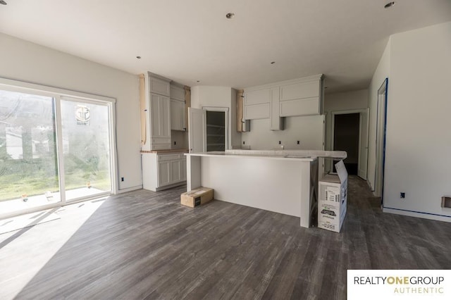 kitchen with a breakfast bar, a center island, and dark wood-type flooring