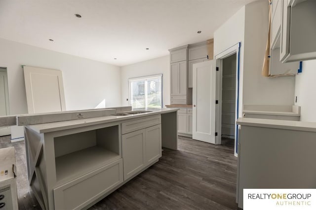 kitchen featuring dark wood-type flooring, a kitchen island, and gray cabinetry