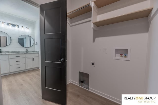 laundry area with sink, hookup for a washing machine, light wood-type flooring, and hookup for an electric dryer