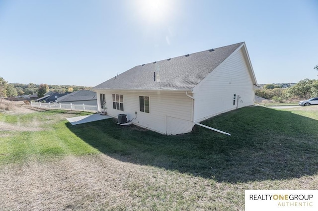 rear view of property with a lawn and central AC