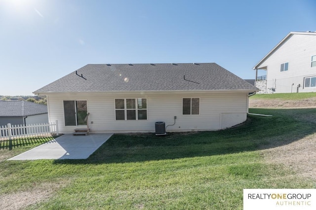 rear view of house featuring central AC unit, a yard, and a patio