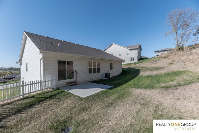 rear view of property with a yard, central AC unit, and a patio area