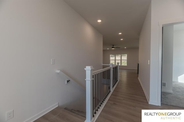 stairs with hardwood / wood-style floors and ceiling fan