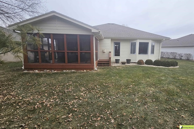 rear view of house featuring a sunroom and a yard