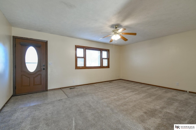 carpeted entrance foyer with ceiling fan