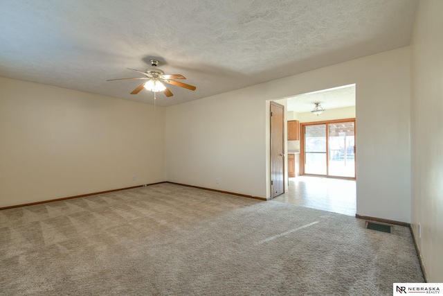 carpeted spare room featuring a textured ceiling and ceiling fan