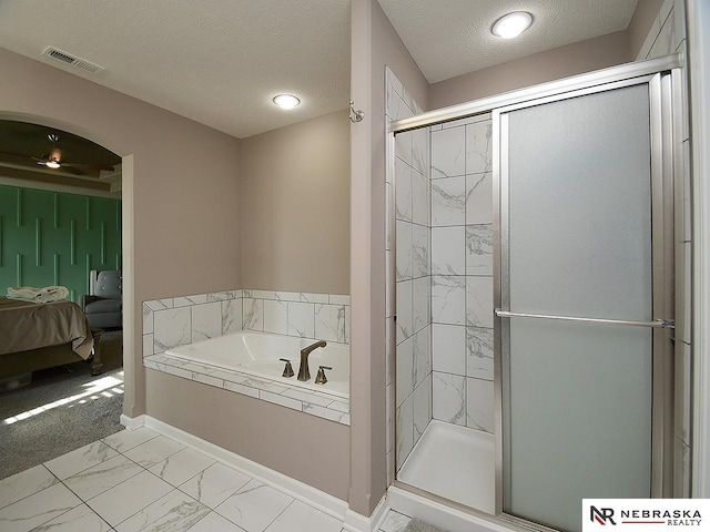 bathroom with independent shower and bath and a textured ceiling