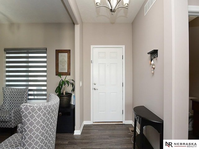 entrance foyer featuring dark wood-type flooring and a chandelier