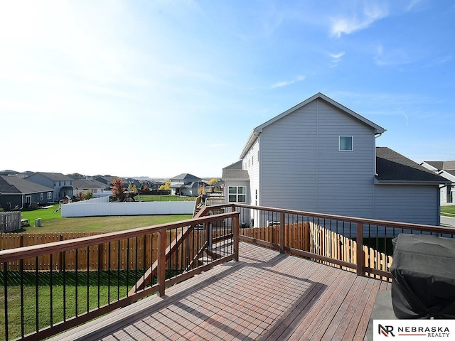 wooden deck featuring area for grilling and a yard