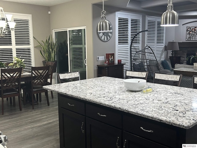 kitchen featuring a center island, a fireplace, dark hardwood / wood-style flooring, and decorative light fixtures