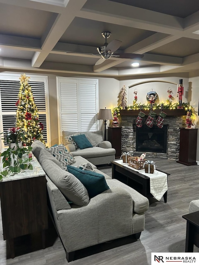 living room with coffered ceiling, beamed ceiling, hardwood / wood-style flooring, ceiling fan, and a fireplace