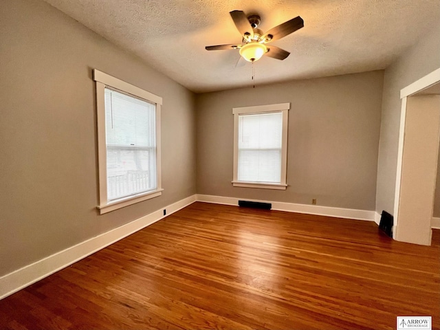 unfurnished room featuring a textured ceiling, ceiling fan, and dark wood-type flooring