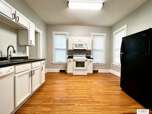 kitchen with white cabinetry, sink, light hardwood / wood-style flooring, a textured ceiling, and white appliances