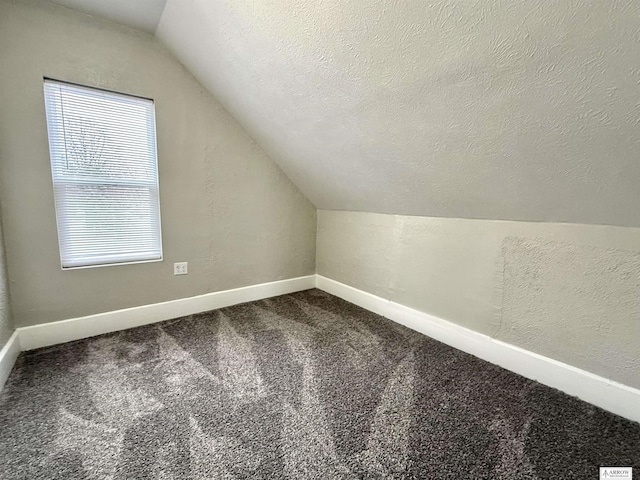 bonus room with plenty of natural light, carpet floors, a textured ceiling, and vaulted ceiling