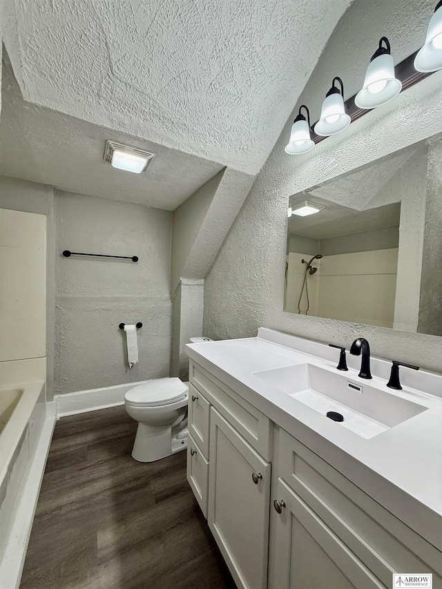 full bathroom with vanity, a textured ceiling, wood-type flooring, shower / tub combination, and toilet