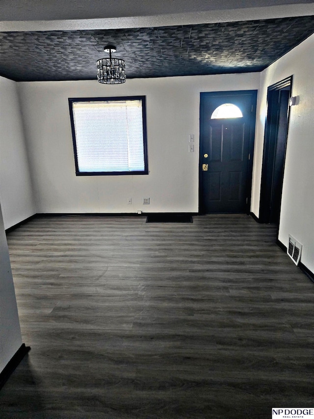 foyer featuring dark hardwood / wood-style flooring and an inviting chandelier