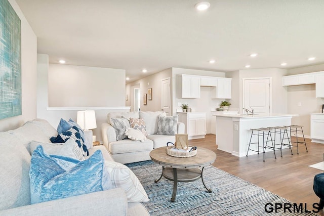 living room with light hardwood / wood-style floors and sink