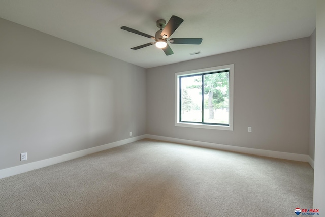 empty room with ceiling fan and light colored carpet