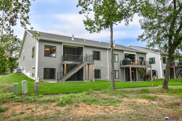 back of property with a deck and a yard