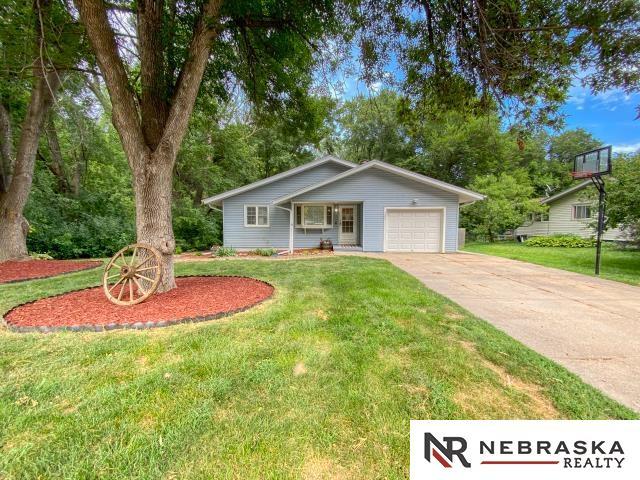 single story home with a front yard and a garage