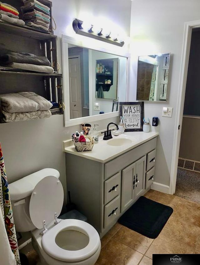 bathroom with tile patterned flooring, vanity, and toilet