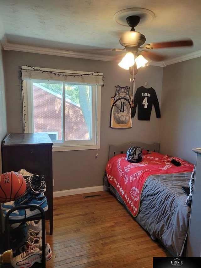 bedroom with hardwood / wood-style flooring, ceiling fan, and ornamental molding