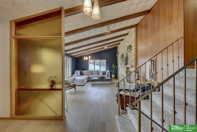 unfurnished living room featuring beam ceiling, a chandelier, high vaulted ceiling, and wood-type flooring