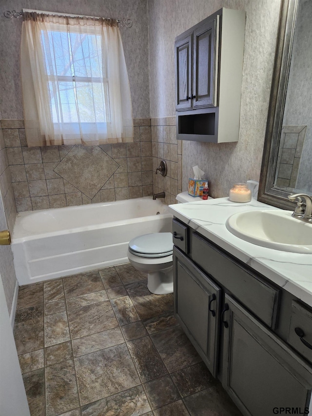 bathroom with a bath, vanity, and toilet