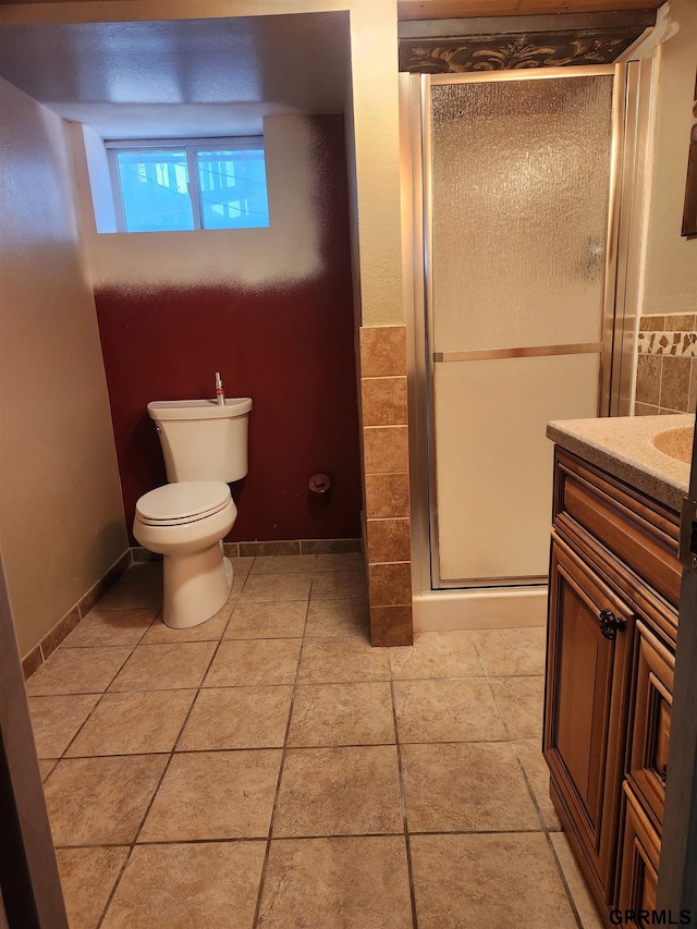 bathroom with tile patterned floors, vanity, toilet, and walk in shower