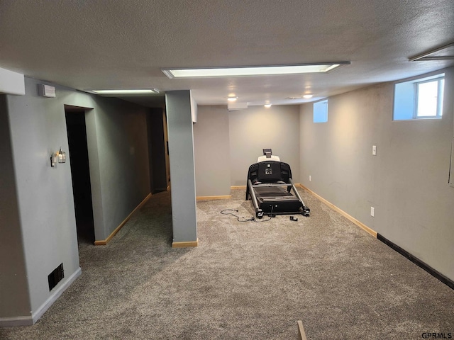 exercise room with carpet flooring and a textured ceiling