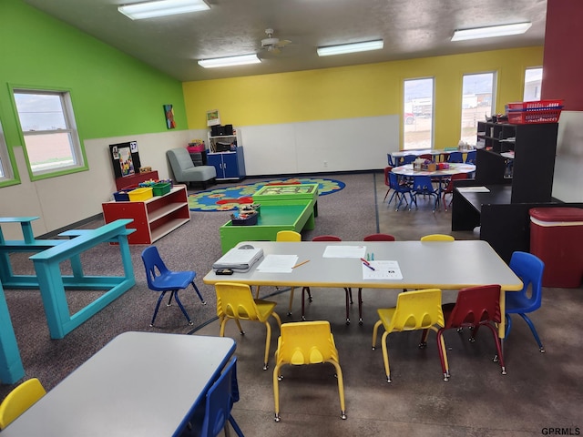 recreation room with ceiling fan and concrete floors