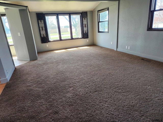 empty room with light colored carpet and vaulted ceiling