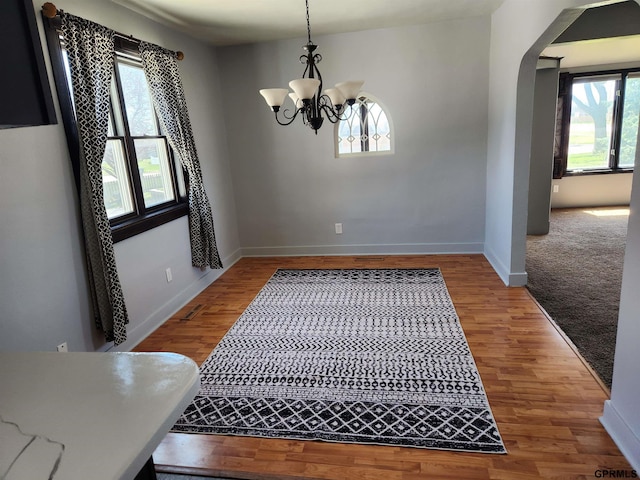 dining space with light hardwood / wood-style flooring and a chandelier