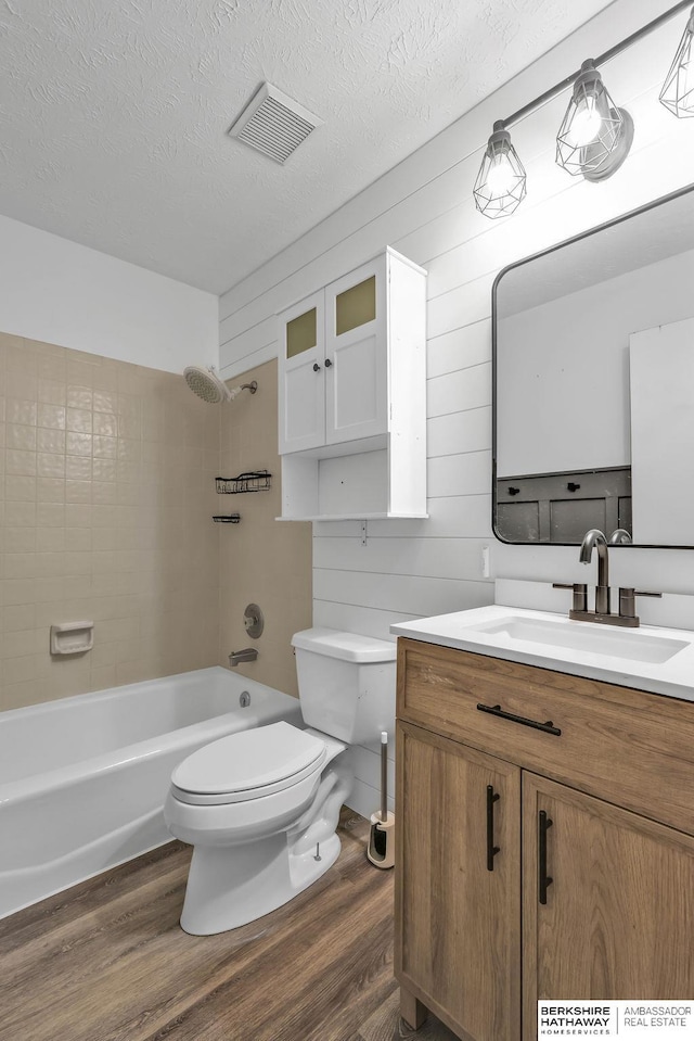 full bathroom featuring wood-type flooring, tiled shower / bath, and wooden walls