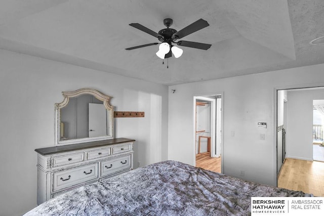 bedroom with ceiling fan, ensuite bathroom, and light hardwood / wood-style floors