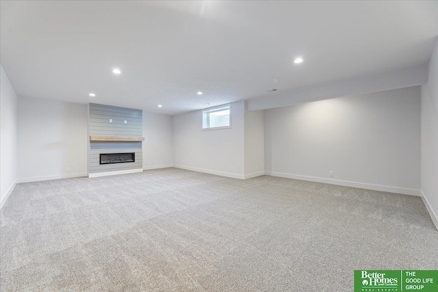 basement featuring a large fireplace and light carpet