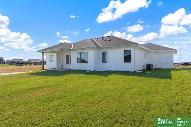 back of property with central AC unit, a patio, and a lawn