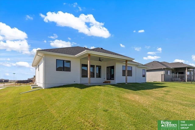 back of house featuring a lawn and ceiling fan