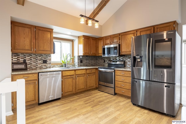 kitchen featuring high vaulted ceiling, decorative backsplash, sink, and appliances with stainless steel finishes