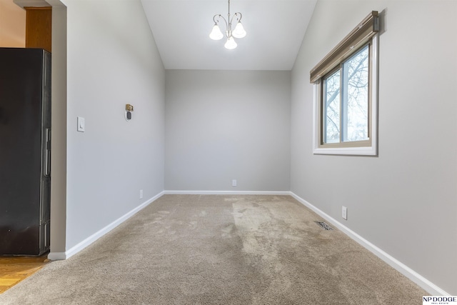 unfurnished room featuring a chandelier, carpet flooring, and lofted ceiling