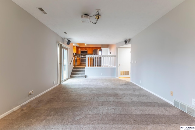 unfurnished living room featuring light colored carpet