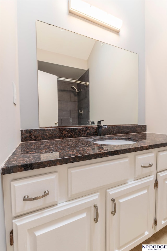 bathroom featuring a tile shower and vanity