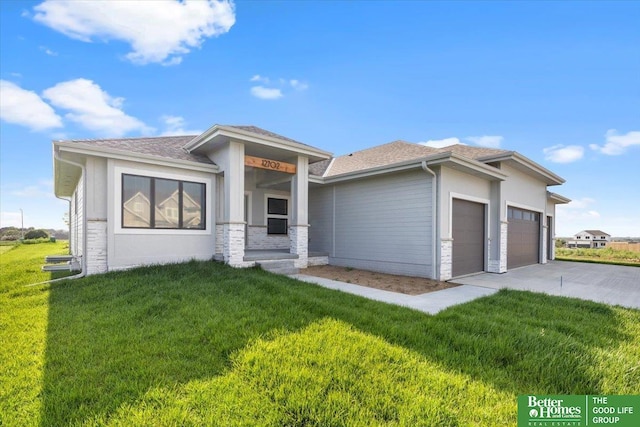 prairie-style house featuring a garage and a front lawn