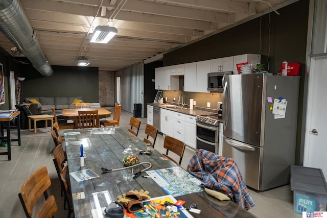 kitchen featuring stainless steel appliances, white cabinetry, and sink