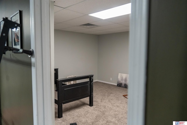 carpeted bedroom featuring a drop ceiling