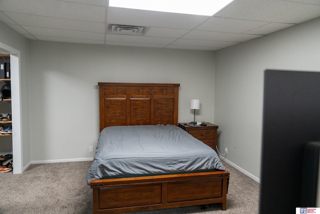 carpeted bedroom featuring a drop ceiling