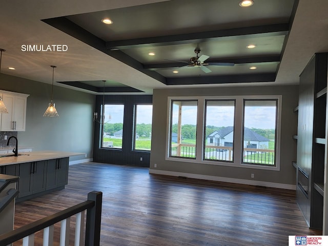 living room with dark hardwood / wood-style flooring, ceiling fan, sink, and a raised ceiling