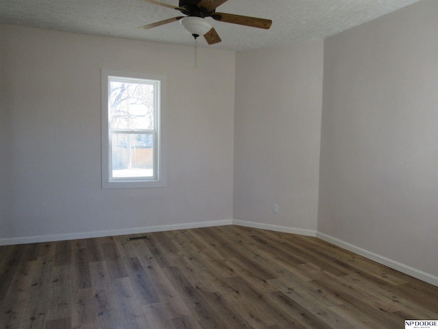 empty room with ceiling fan and dark wood-type flooring