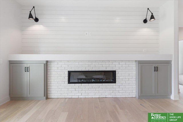 details with hardwood / wood-style flooring and a brick fireplace