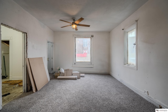 spare room with ceiling fan, carpet floors, and a wealth of natural light